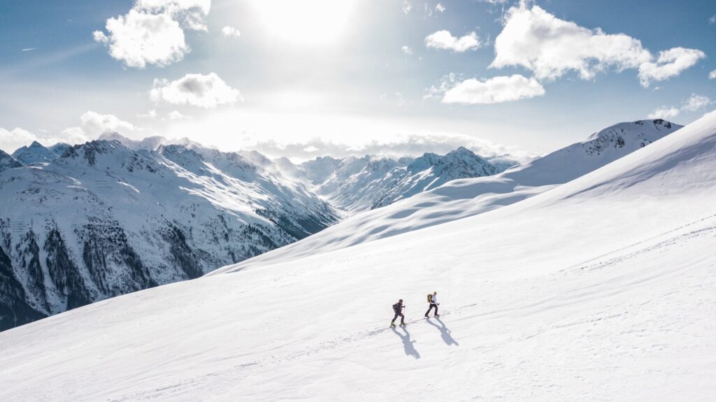 two hikers walking in a snowy mountain range