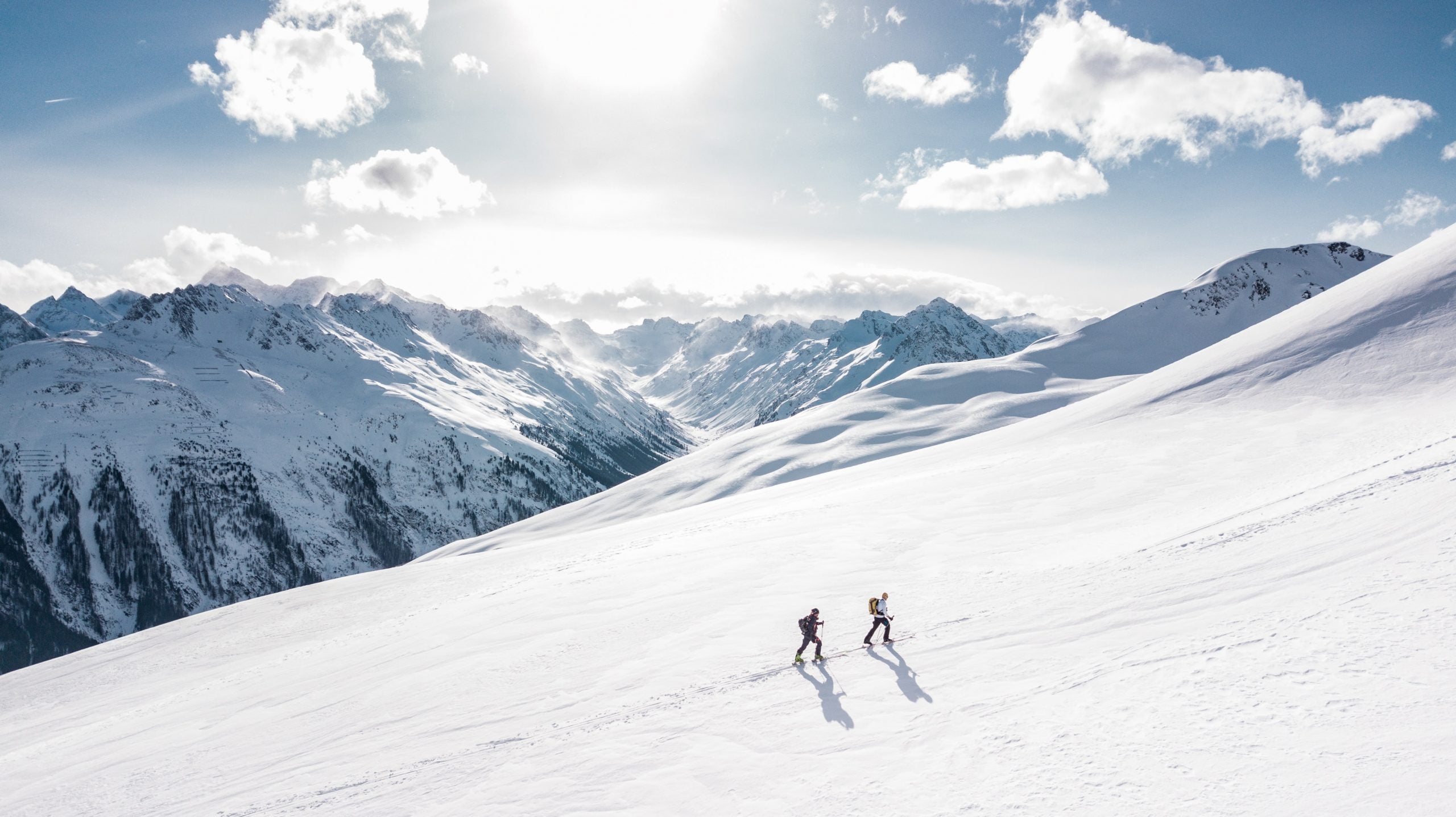 two hikers walking in a snowy mountain range